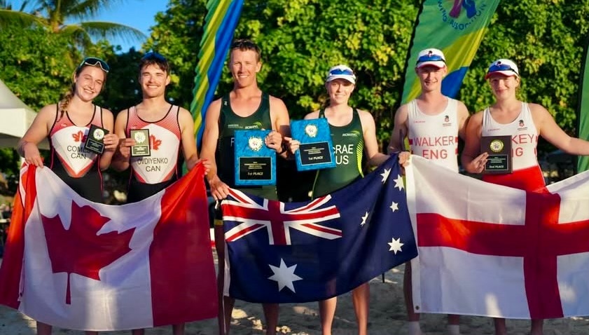 Seis personas sostienen las banderas y medallas de sus países y sonríen a la cámara.