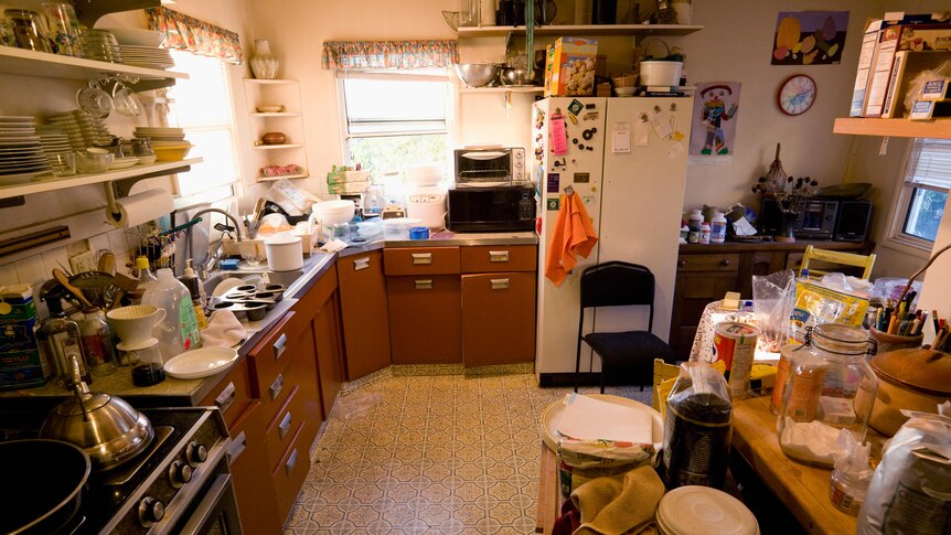 Cluttered kitchen with overflowing kitchen counter 