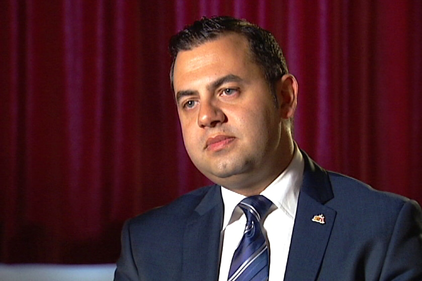 A man wearing a suit sitting down