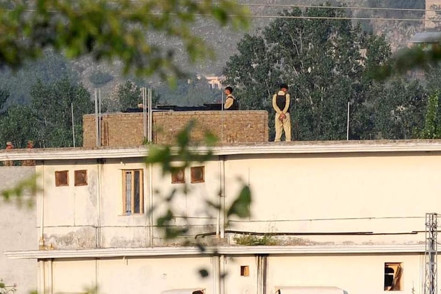 Pakistani soldiers stand guard on top of a building at the hideout of Osama bin Laden