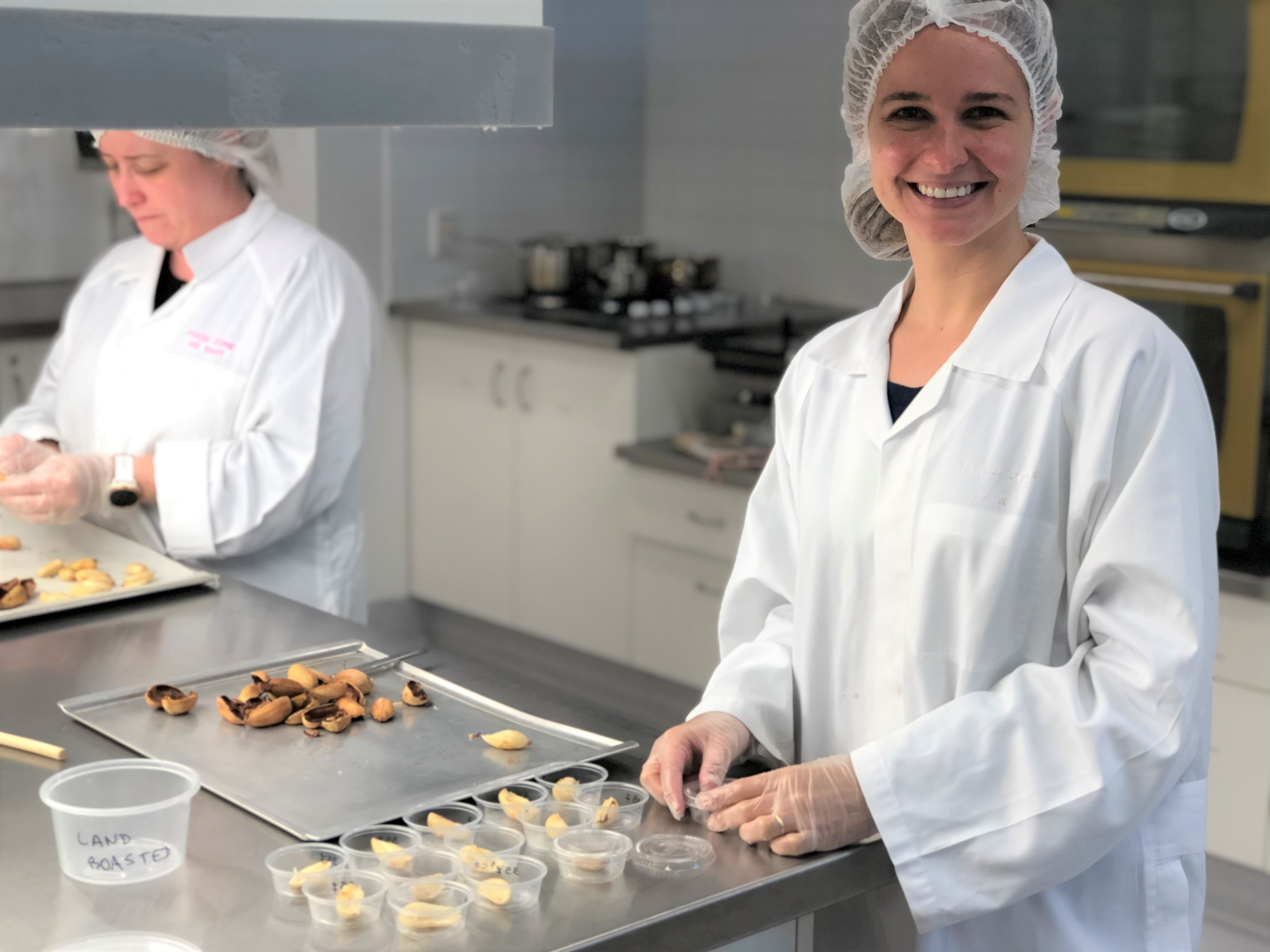 Two women in lab coats testing bunya nuts in a lab.