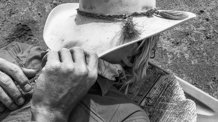 A hard-working western grazier takes a moment off, under his hat.