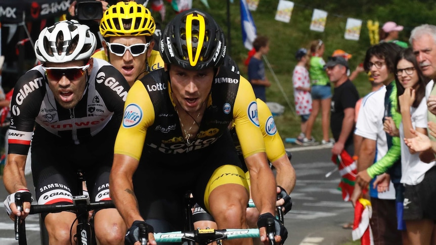 Primoz Roglic looks focused riding ahead of Tom Dumoulin and Geraint Thomas up a mountain.