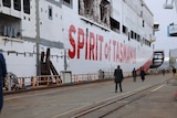 The side of a ship under construction with Spirit of Tasmanian in red text on a white background.