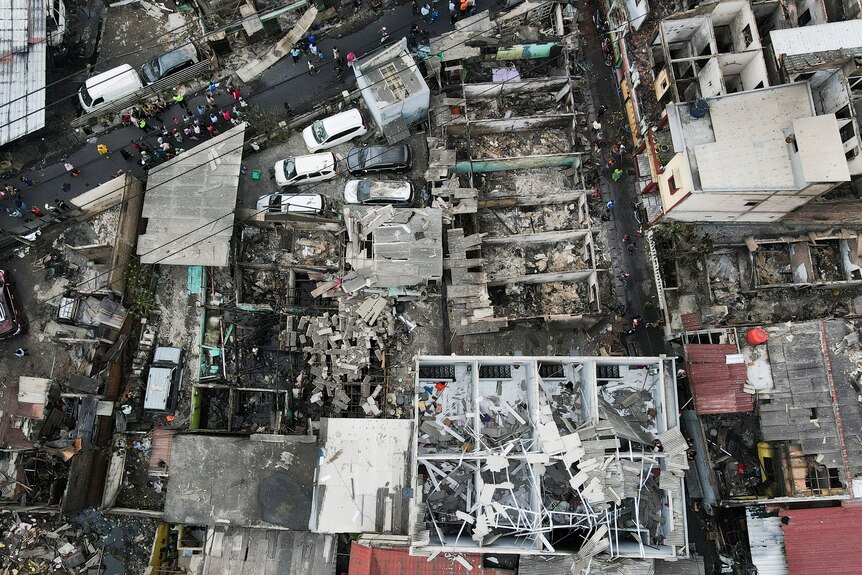 An aerial view shows ruins and damaged vehicles at a residential area that's been affected after a fire