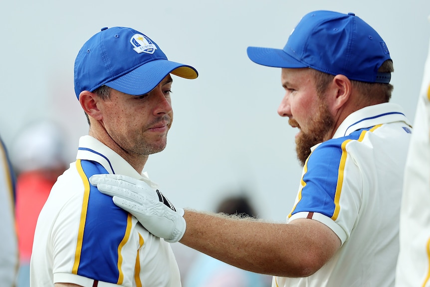 Rory McIlroy looks sad as Shane Lowry puts his hand on McIlroy's chest