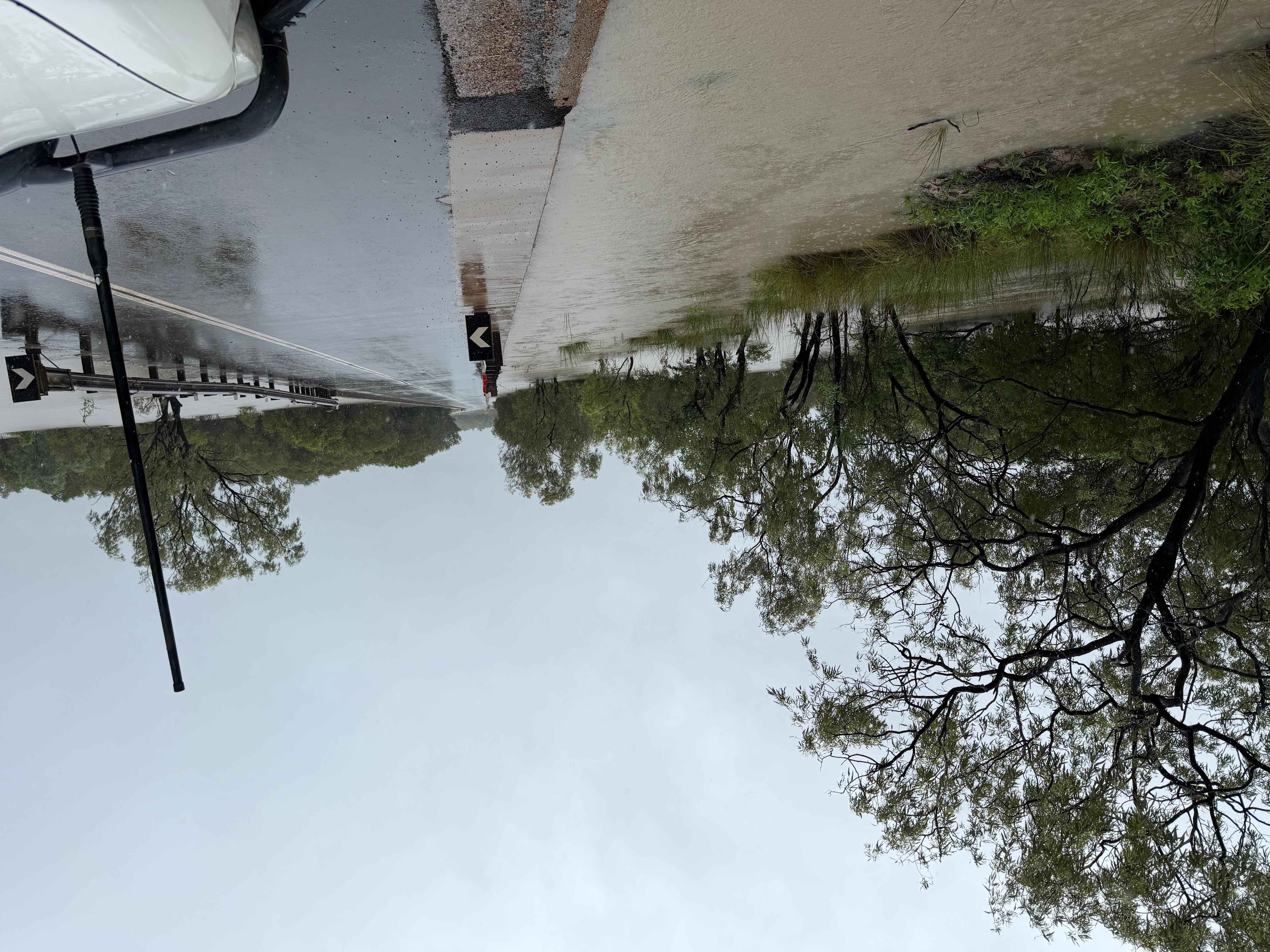 A água da enchente está perto do topo de uma ponte que atravessa um rio.