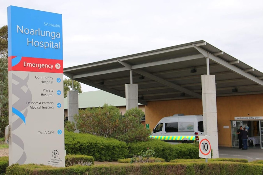 Noarlunga Hospital sign and entrance with ambulance in view.