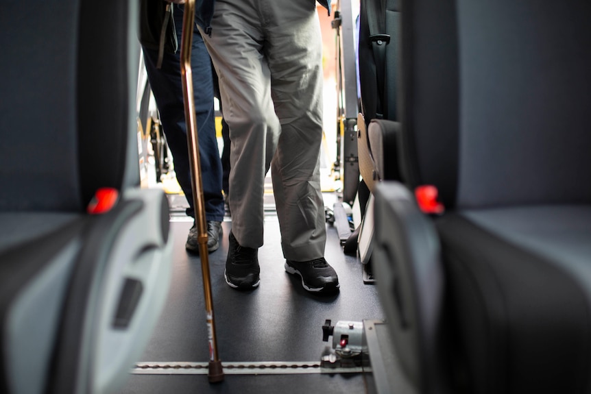 An elderly man's legs walk onto a ramp