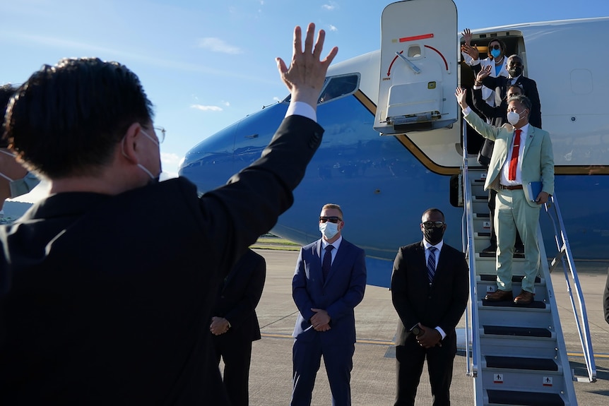 People wave from a plane.