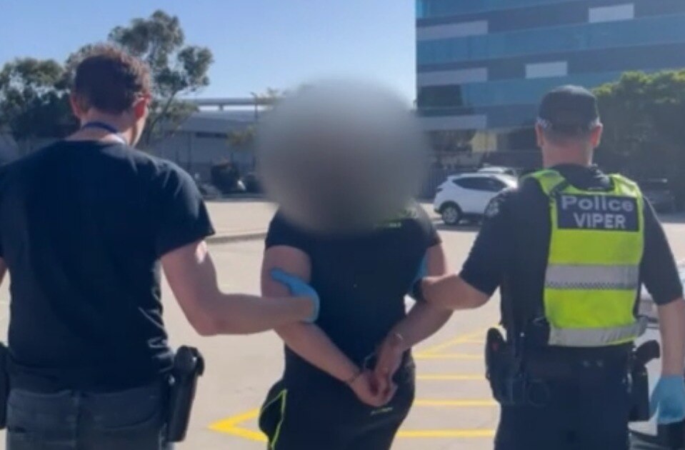 A man being led by two police officers.