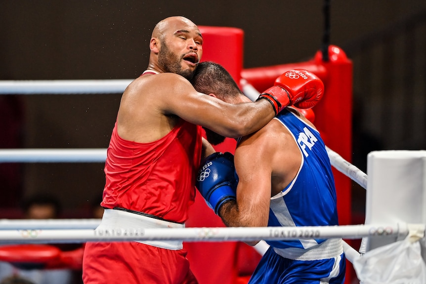 Two male boxers come together in the ting at the Tokyo Olympics.