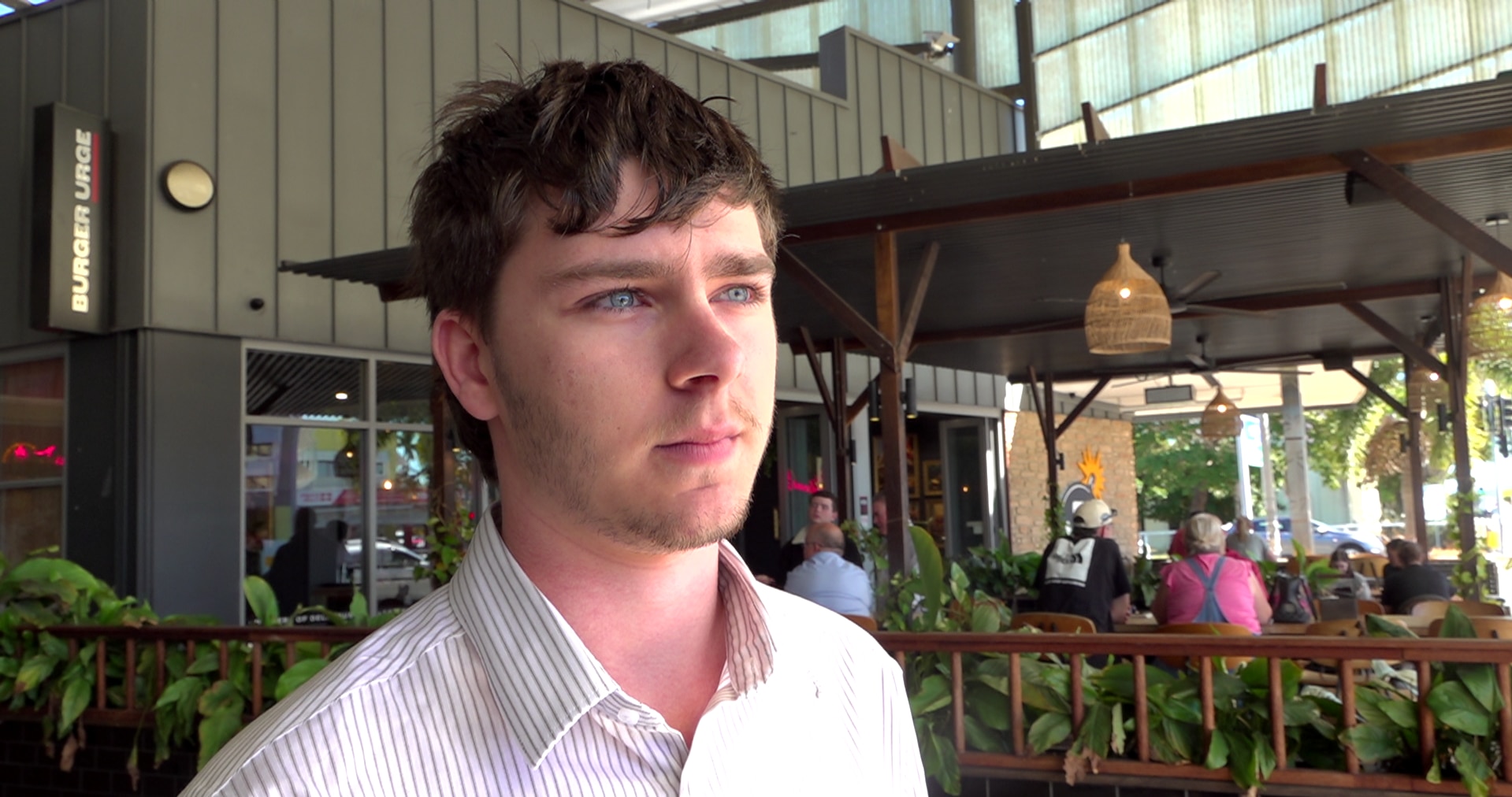 Man with blue eyes and dark hair looks off centre