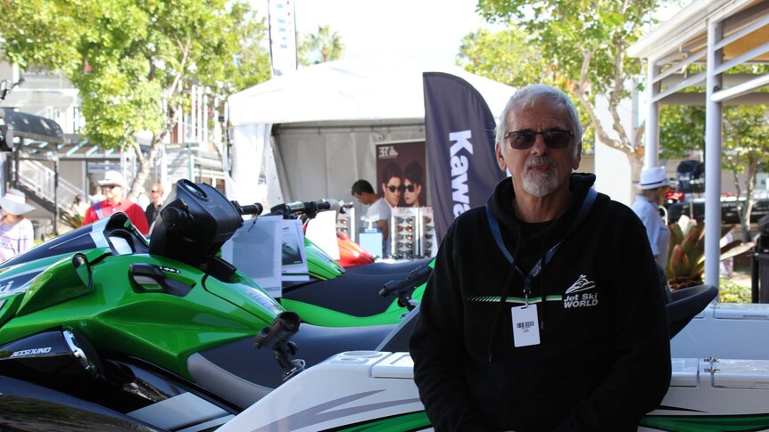 John Moyle stands in front of a row of jet skis at the Sanctuary Cove boat show.