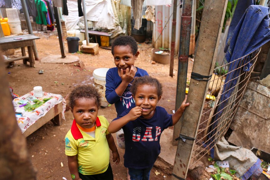 Three small children in PNG smiling for the camera