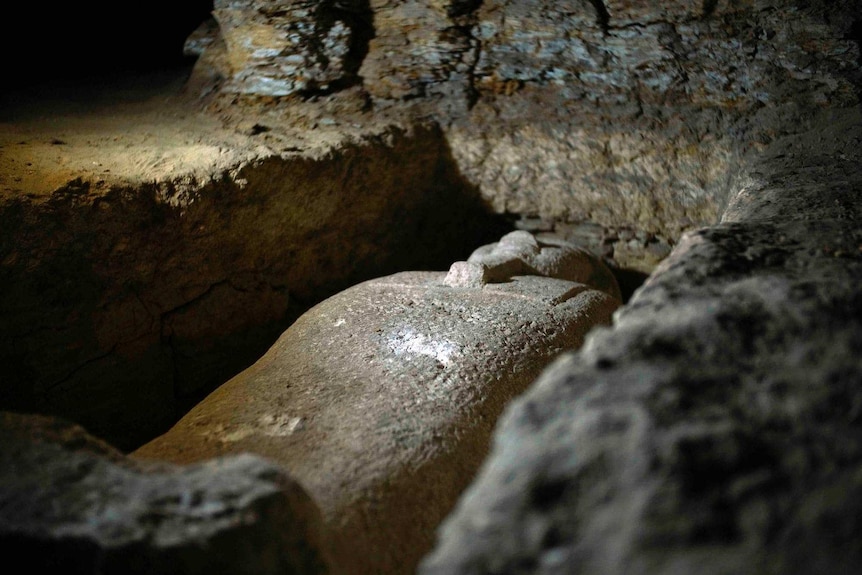 A limestone coffin buried in rock