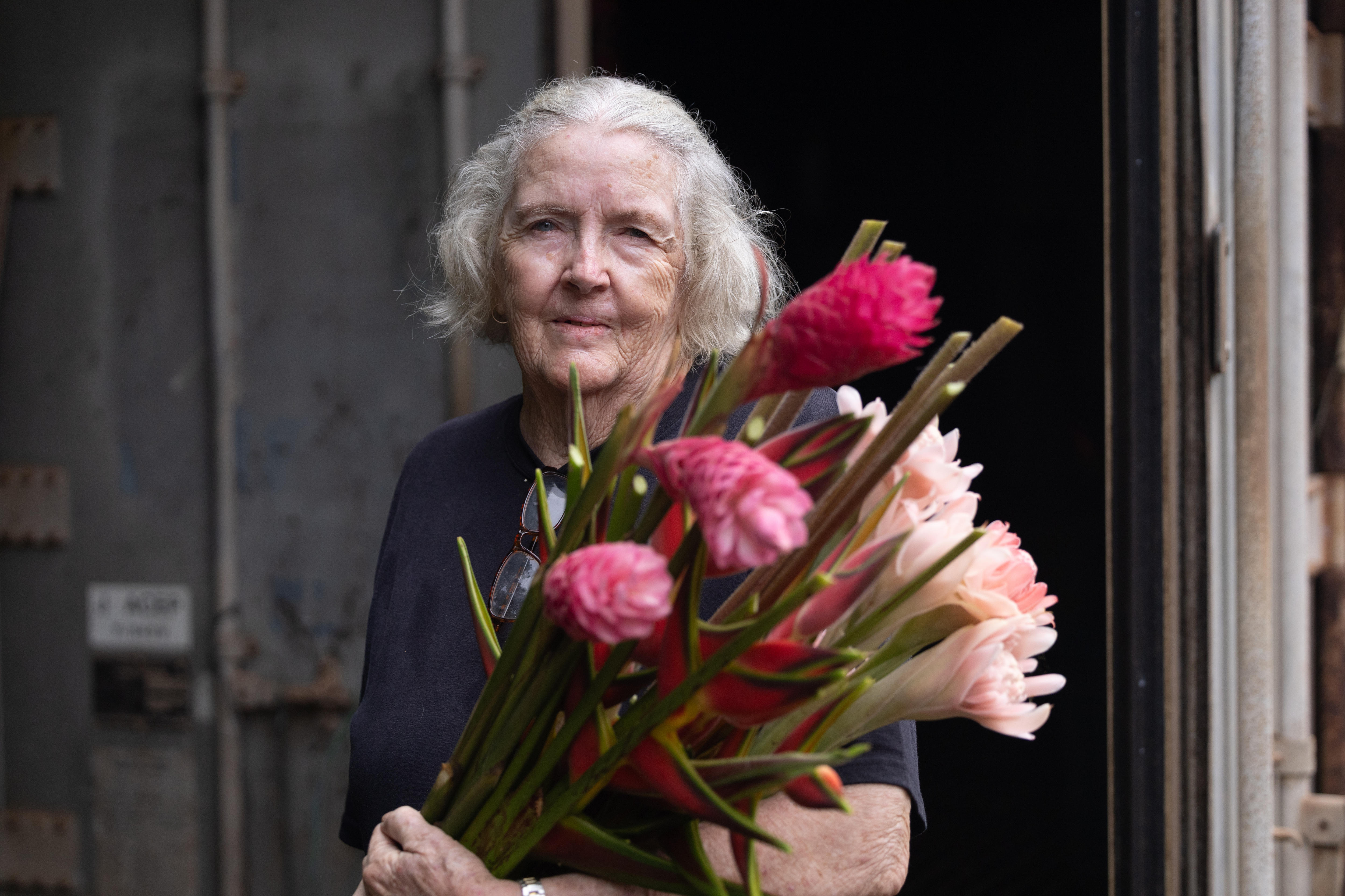 A woman holds a bunch of pink flowers 