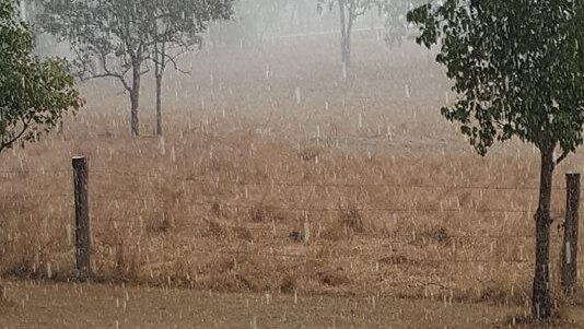 rain falling on a property with puddles on the grass