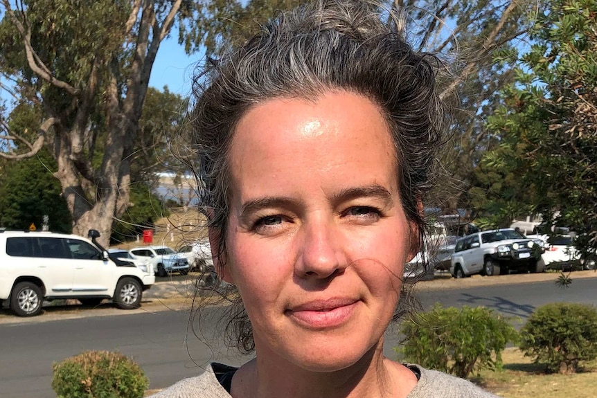 Christy Bryar stands outside under a tree in Mallacoota.