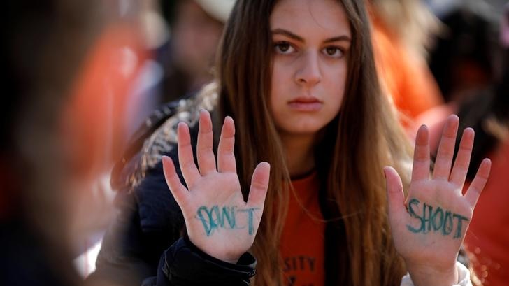 Student holds her hands up with the words don't shoot written on the palms