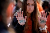 Student holds her hands up with the words don't shoot written on the palms