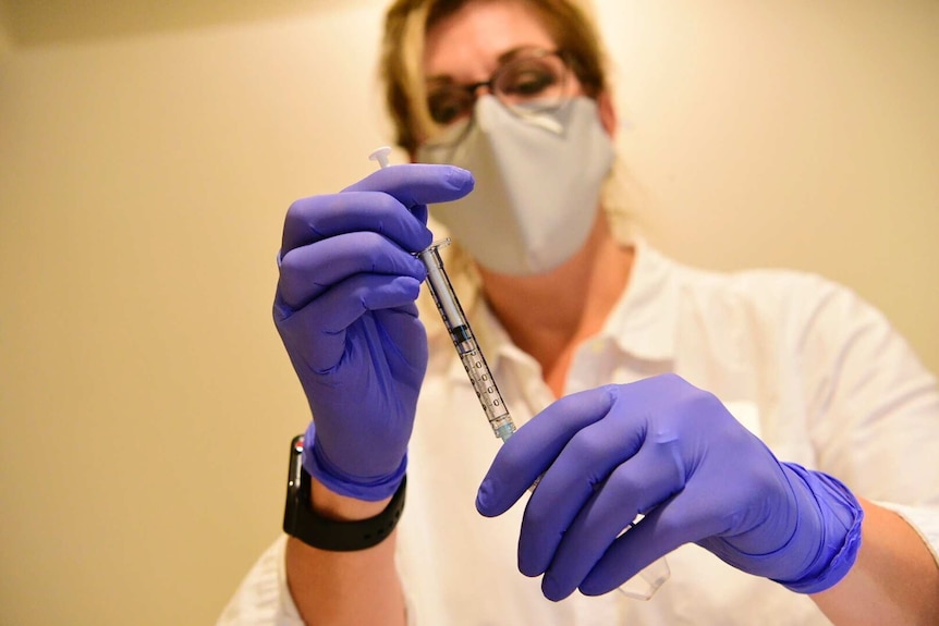 Pharmacists prepares to give a vaccine.