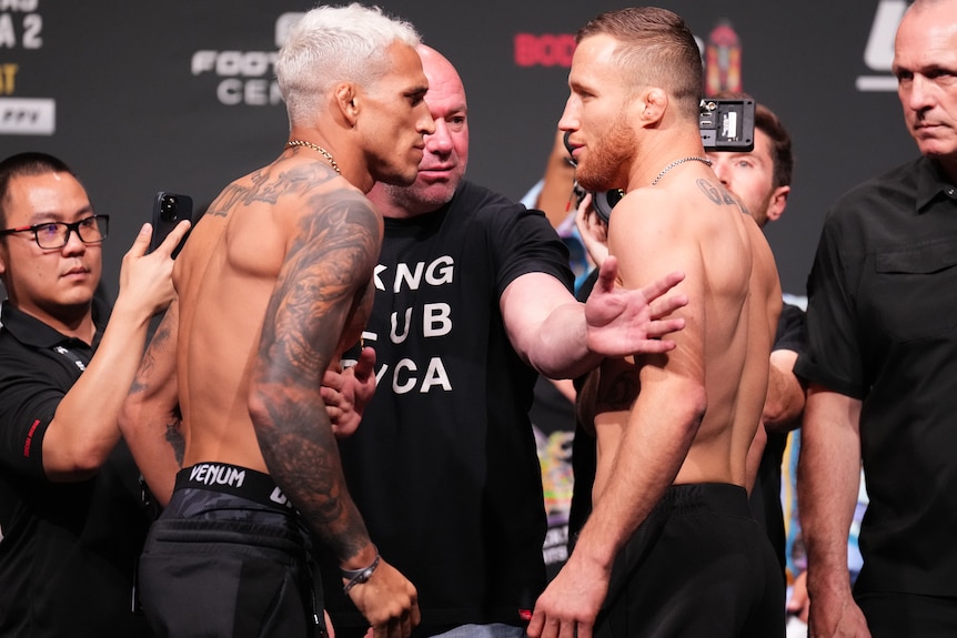 Charles Oliveira and Justin Gaethje face each other and look menacing