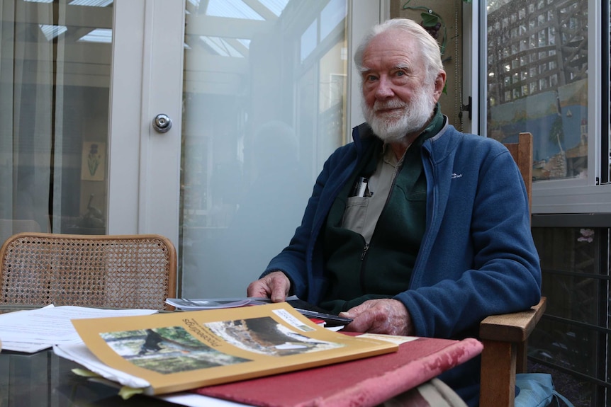 A man sitting at a table with documents in front of him.