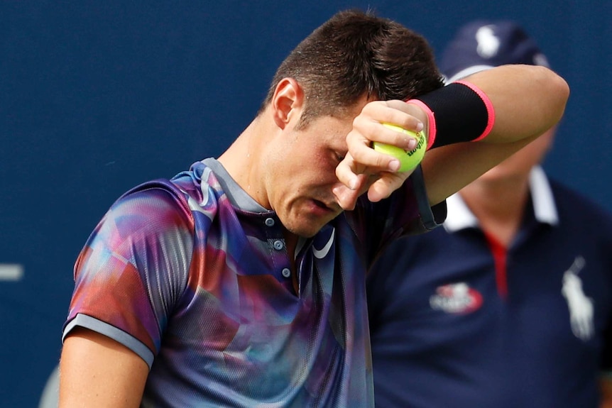 Bernard Tomic wipes sweat from his brow at US Open.