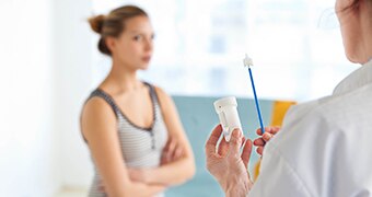 Woman and doctor with Pap smear brush