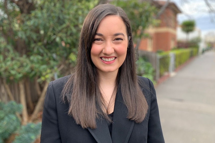 A woman wearing a dark suit.