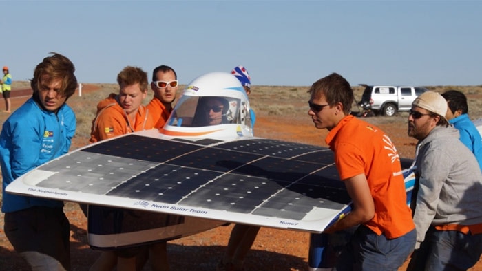 Team members lift the World Solar Challenge-winning Nuna7 car.