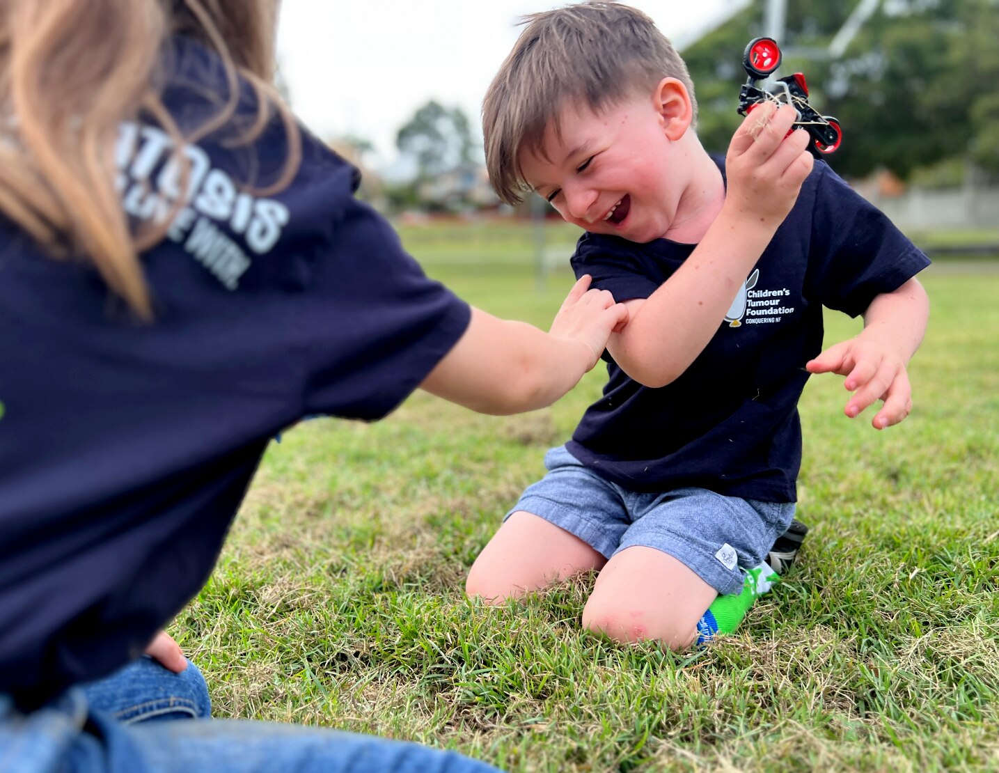 young boy playing with a toy motorbike