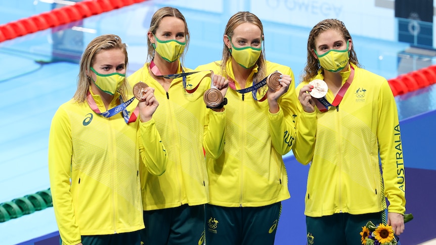 Four women holding up their bronze medal at the Tokyo Olympics