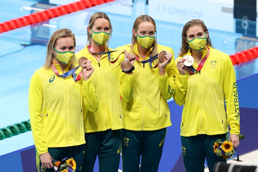Four women holding up their bronze medal at the Tokyo Olympics