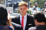 A man in a suit walks in front of a court house building