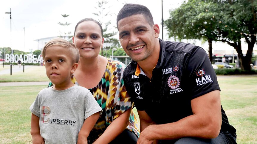Young Aboriginal boy with his mother, with a man in a black shirt.