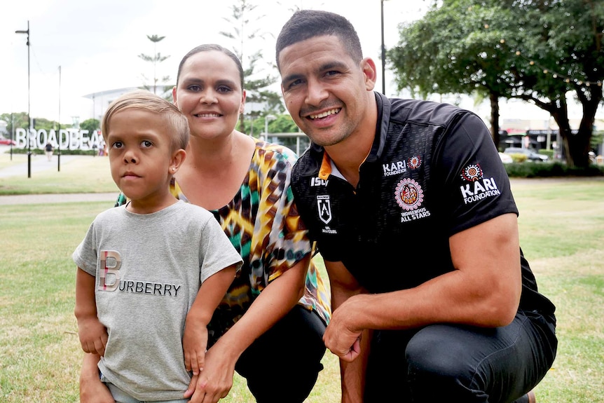 Young Aboriginal boy with his mother, with a man in a black shirt.