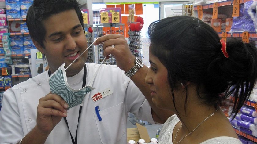 Pharmacy workers in Tasmania demonstrate face masks.