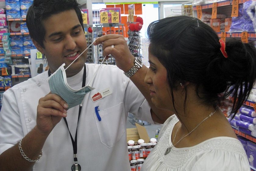 Pharmacy workers in Tasmania demonstrate face masks.