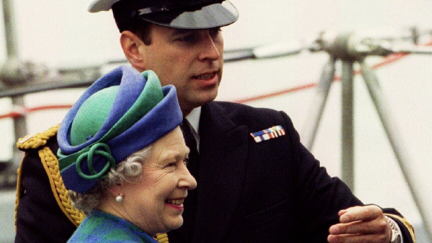 The Queen and Prince Andrew stand aboard a Royal Navy ship deck as the Royal directs the sovereign to another location.