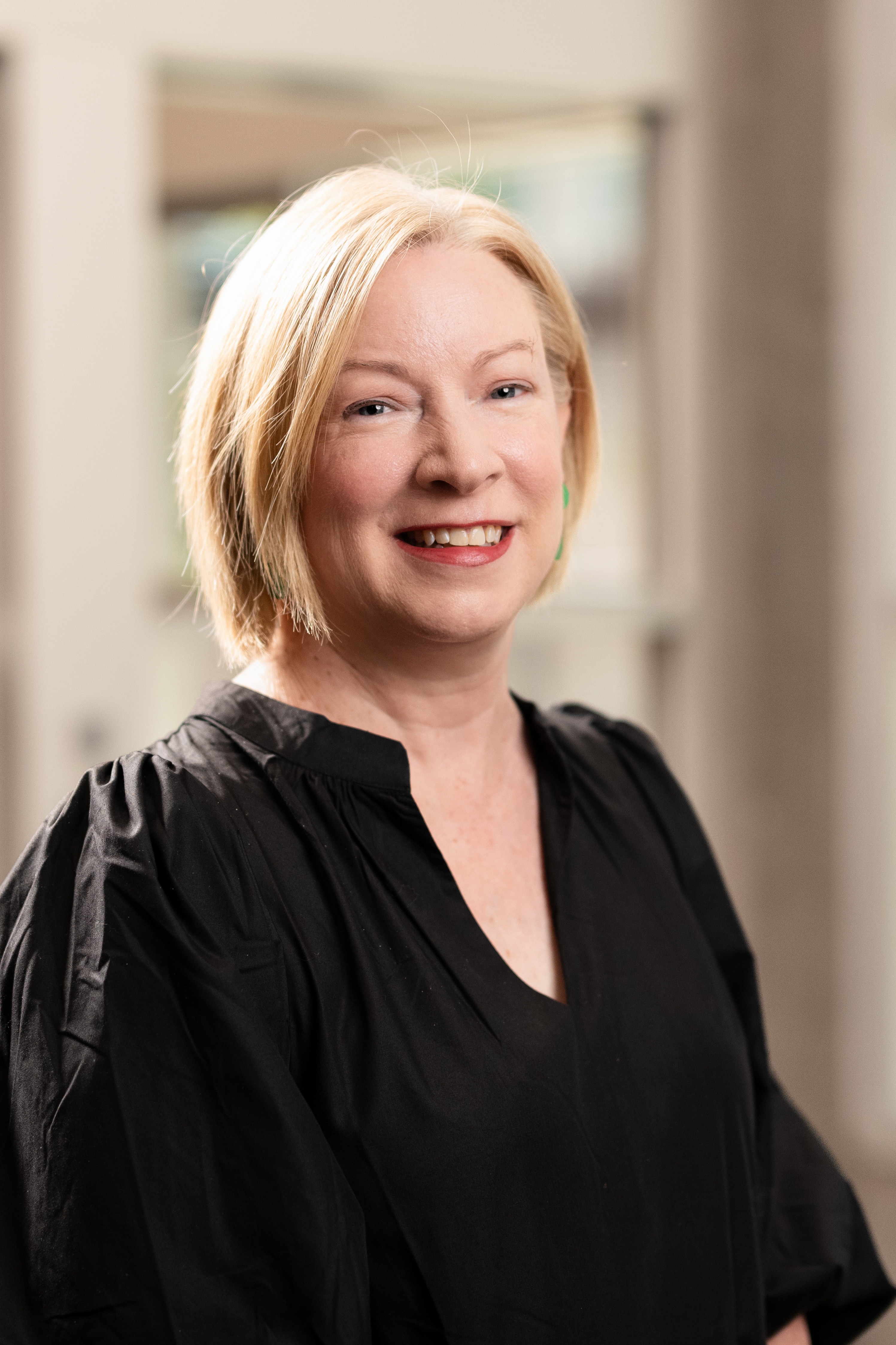 A blonde woman smiles at the camera.
