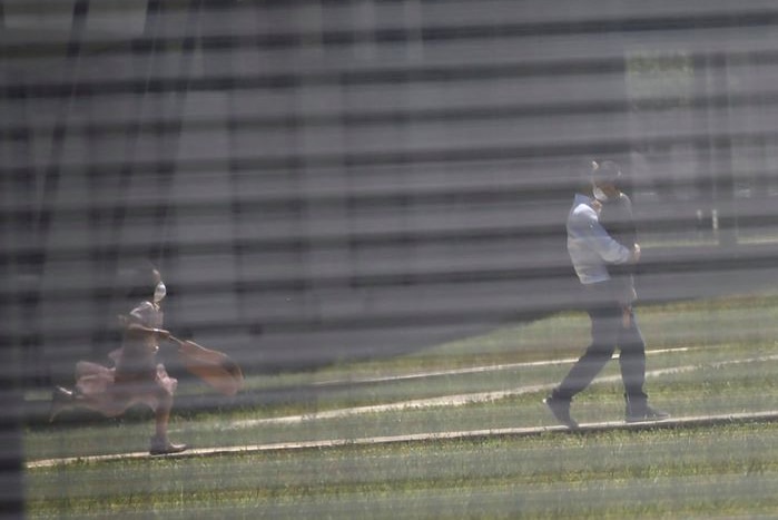 A man and two children play inside the fence of the quarantine station on Christmas Island.