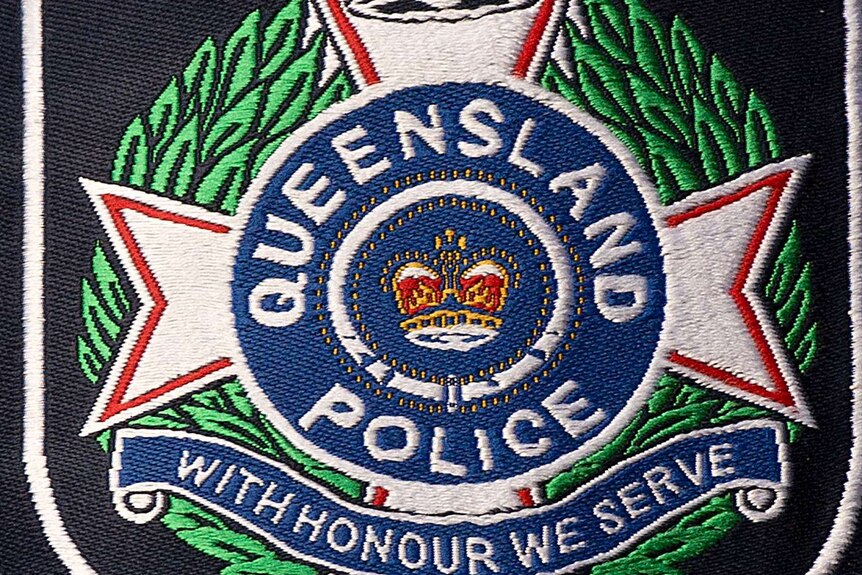 Queensland police logo on shirt sleeve.