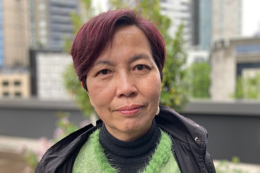 A profile photo of woman in a green jumper who is looking at the camera.