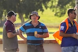 Men at sporting match hold beers while in conversation