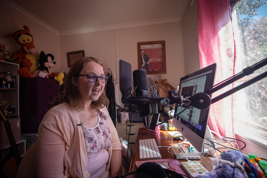 Tiarna Kemp speaks into a microphone as she sits at her computer.