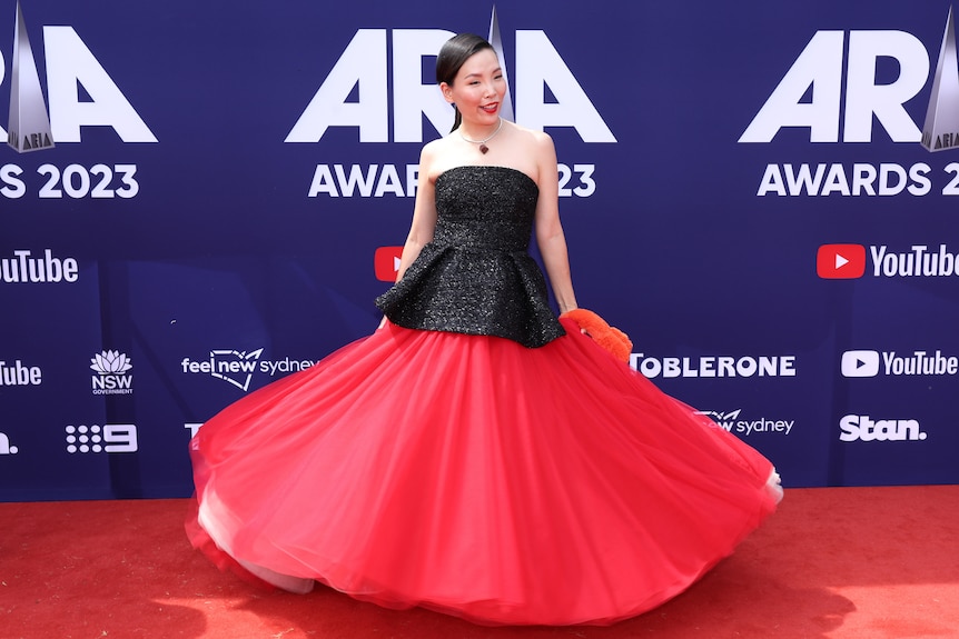 A lady wearing a black and red dress twirling