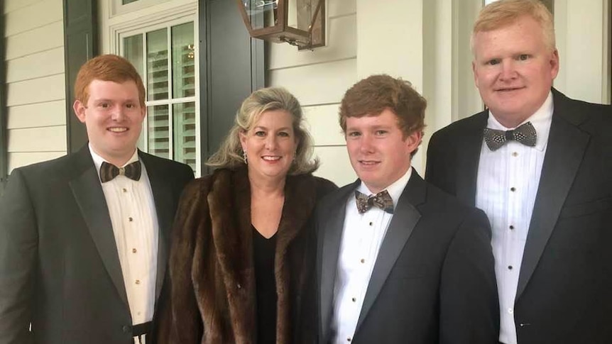 Buster Murdaugh in a suit next to Maggie Murdaugh and Paul Murdaugh with Alex Murdaugh on the right