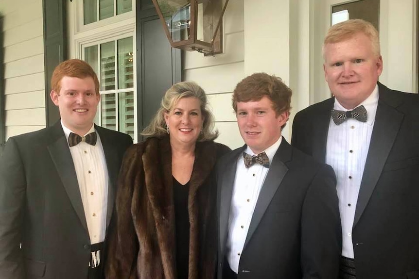 Buster Murdaugh in a suit next to Maggie Murdaugh and Paul Murdaugh with Alex Murdaugh on the right